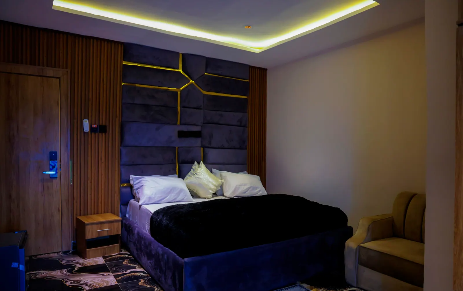 A Deluxe Room, with an inlaid navy headboard