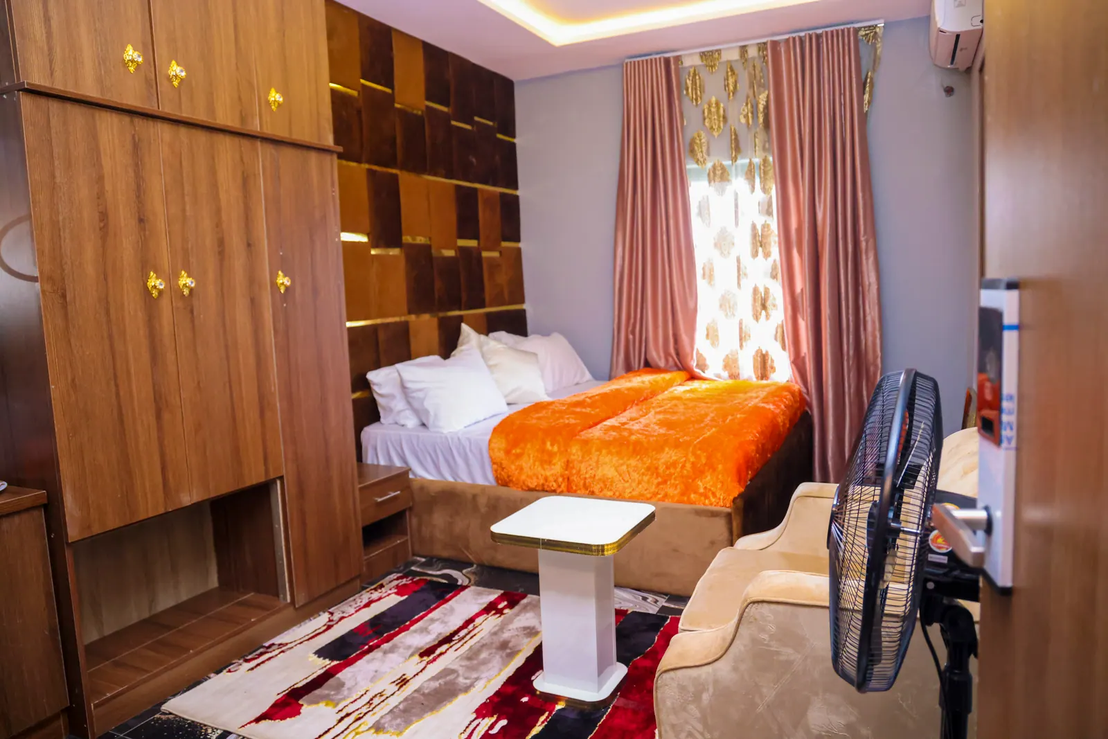 A Premium Suite, with a wood-panelled wall and orange bedspread