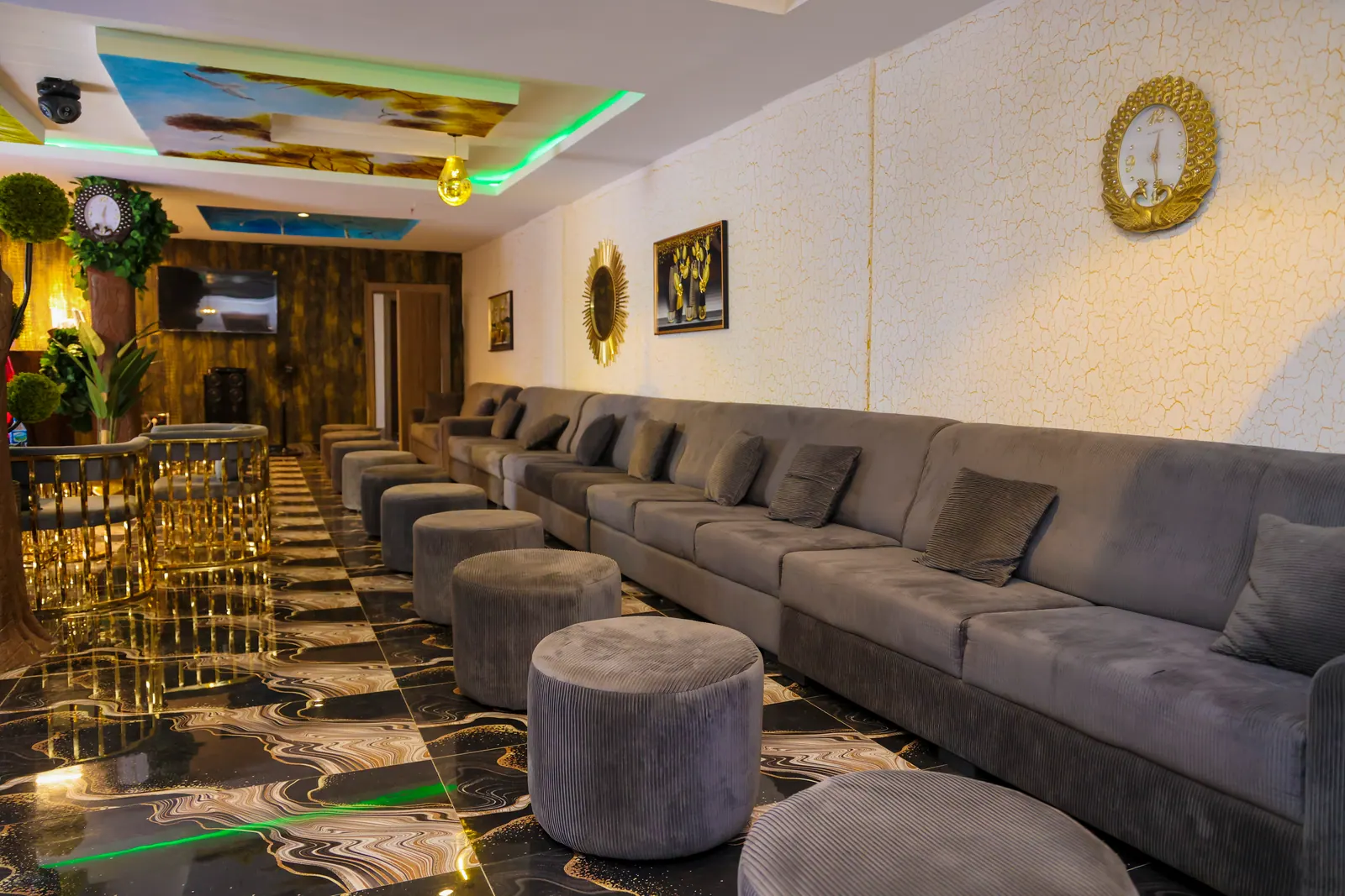 The club lounge, with a long grey sofa and the gold bar beyond